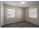 Cozy bedroom with neutral walls, soft carpet, and bright, natural light from two large windows with blinds at 3418 Longleaf Dr, Decatur, GA 30032