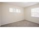 A bright bedroom showcasing neutral walls, plush carpeting, and two windows with blinds for great natural light at 3418 Longleaf Dr, Decatur, GA 30032