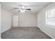 Spacious living room featuring plush carpeting, neutral walls, and a modern ceiling fan with light fixture at 3418 Longleaf Dr, Decatur, GA 30032