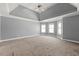 Large main bedroom with tray ceiling, carpet, and window seat at 6202 Millstone Trl, Douglasville, GA 30135