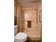 This is a walk-in shower with stone tile, built-in shelves and handrails at 1800 Clairmont Lk # 413, Decatur, GA 30033
