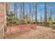 Backyard view with a mix of manicured lawn, tall trees, and a charming red picket fence at 2791 Ponderosa Cir, Decatur, GA 30033