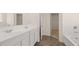Double vanity bathroom with white cabinets and grey tile floor at 1029 Blue Juniper Cir, Loganville, GA 30052