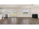 Open concept kitchen and living area with hardwood floors and fireplace at 1029 Blue Juniper Cir, Loganville, GA 30052