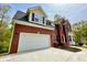 Two-story brick home with attached garage and a large driveway at 1240 Falls Creek Ct, Conyers, GA 30094