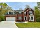 Two-story brick home with attached garage and landscaped yard at 1240 Falls Creek Ct, Conyers, GA 30094