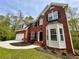Two-story brick home with attached garage, bay window and landscaped yard at 1240 Falls Creek Ct, Conyers, GA 30094