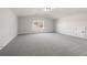 Bright bonus room with gray carpeting and a large window at 2615 Yellowstone Farm Dr, Cumming, GA 30028