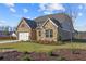 House with stone and brick exterior, a three car garage, and a large lawn at 2615 Yellowstone Farm Dr, Cumming, GA 30028