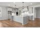 Open-concept kitchen with an island, gray cabinets, and hardwood floors at 2615 Yellowstone Farm Dr, Cumming, GA 30028