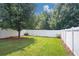 Landscaped backyard features green grass and a white wooden fence surrounding the perimeter at 5140 Sky Ridge Way, Cumming, GA 30041