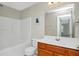 A clean bathroom with a shower-tub combo and wooden vanity sink at 5140 Sky Ridge Way, Cumming, GA 30041