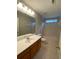 A well-lit bathroom offers a shower-tub combo and wooden vanity sink at 5140 Sky Ridge Way, Cumming, GA 30041