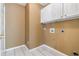 Laundry room with white cabinets and tiled floor at 643 Rangeley Meadows Ct, Hampton, GA 30228