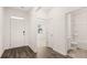 Foyer showcasing wood-style flooring, white walls, and a bathroom with a toilet and sink at 8589 Seabiscuit Rd, Lithonia, GA 30058