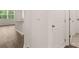 Hallway view featuring wood-style flooring and white trim, leading to an open-concept kitchen area at 8589 Seabiscuit Rd, Lithonia, GA 30058