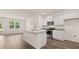 Open kitchen boasts white cabinets, stainless appliances, and a granite island at 8589 Seabiscuit Rd, Lithonia, GA 30058
