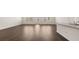 Spacious living room featuring beautiful dark wood floors, large windows, and neutral paint at 8589 Seabiscuit Rd, Lithonia, GA 30058