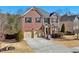 Attractive two-story red brick home featuring a two-car garage and well-maintained landscaping at 1565 Horseshoe Creek Ln, Cumming, GA 30041