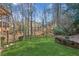 Green lawn with landscaping and treeline in backyard at 3611 Howell Wood Trl, Duluth, GA 30096