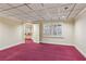 Finished basement with a red carpet, neutral walls, drop ceiling, and a partial view of a bar area at 3611 Howell Wood Trl, Duluth, GA 30096