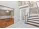 Open foyer with staircase and marble floors leads to formal dining room featuring hardwood floors and decorative chandelier at 3611 Howell Wood Trl, Duluth, GA 30096