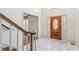 Bright foyer with tile flooring, a wooden staircase, and a decorative glass front door at 3611 Howell Wood Trl, Duluth, GA 30096