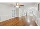 Open-concept living room with hardwood floors leads into a modern kitchen with white cabinets and granite countertops at 3611 Howell Wood Trl, Duluth, GA 30096