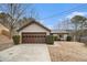 Tan house with brown garage door, driveway, and manicured bushes at 546 Paden Dr, Lawrenceville, GA 30044