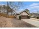 Side view of tan house with brown garage door and wooden fence at 546 Paden Dr, Lawrenceville, GA 30044