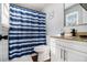 Clean bathroom with blue and white striped shower curtain at 6492 Swift Creek Rd, Lithonia, GA 30058