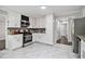 Modern kitchen with white cabinets, stainless steel appliances, and marble flooring at 6492 Swift Creek Rd, Lithonia, GA 30058