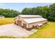 Tan barn with three large brown garage doors and side shed at 350 Taylor Path, Dallas, GA 30157