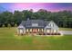 Stunning farmhouse at dusk with red door and gray roof at 350 Taylor Path, Dallas, GA 30157
