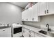 Bright laundry room with white cabinets, granite countertops, and a utility sink at 350 Taylor Path, Dallas, GA 30157