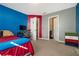 Bedroom with red and blue walls, ensuite bathroom access, and a carpeted floor at 4851 Planters Walk, Douglasville, GA 30135