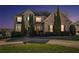 Two-story brick home at dusk featuring manicured landscaping and a welcoming front entrance at 4851 Planters Walk, Douglasville, GA 30135