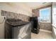 Laundry room with washer, dryer, and stone-textured accent wall at 4851 Planters Walk, Douglasville, GA 30135