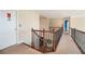 Bright upper hallway with a staircase and neutral carpeting at 4851 Planters Walk, Douglasville, GA 30135