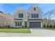 Two-story light brick home with dark brown garage door and manicured lawn at 3921 Enclave Way, Tucker, GA 30084