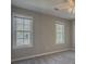 Bright bedroom with grey carpet and two large windows at 601 Ashton Ln, Lawrenceville, GA 30044