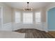 Sunlit breakfast nook featuring modern chandelier, wainscoting, and wood flooring at 406 River Walk, Douglasville, GA 30134