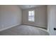 A neutral-toned bedroom features a large window providing ample natural light and soft carpeting at 96 Rome St, Temple, GA 30179