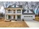 Two-story farmhouse with front porch, attached garage, and landscaped yard at 96 Rome St, Temple, GA 30179