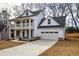 Two-story farmhouse with front porch, attached garage, and landscaped yard at 96 Rome St, Temple, GA 30179