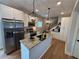 Kitchen boasts stainless steel appliances, granite countertops, a center island, and stylish pendant lighting at 96 Rome St, Temple, GA 30179