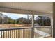 Covered porch overlooking a wooded lot and a paved street at 96 Rome St, Temple, GA 30179