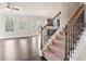 Elegant staircase with dark wood railing and carpeted steps at 3807 Lockaby Way, Lawrenceville, GA 30044