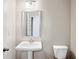 Simple bathroom with pedestal sink, toilet and vanity mirror at 3807 Lockaby Way, Lawrenceville, GA 30044