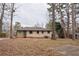 Large backyard with mature trees and a partially paved area at 785 Jett Rd, Jonesboro, GA 30236